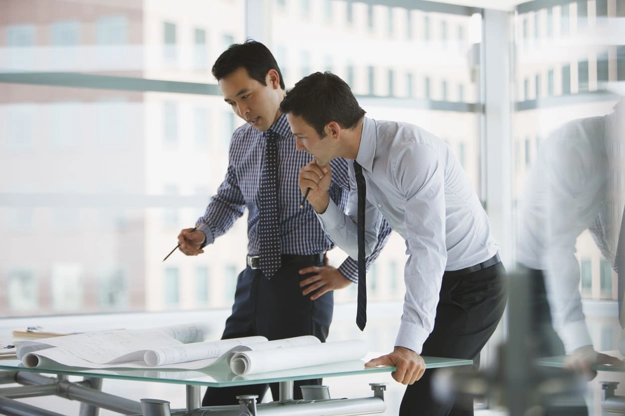 Coworkers reviewing architectural prints