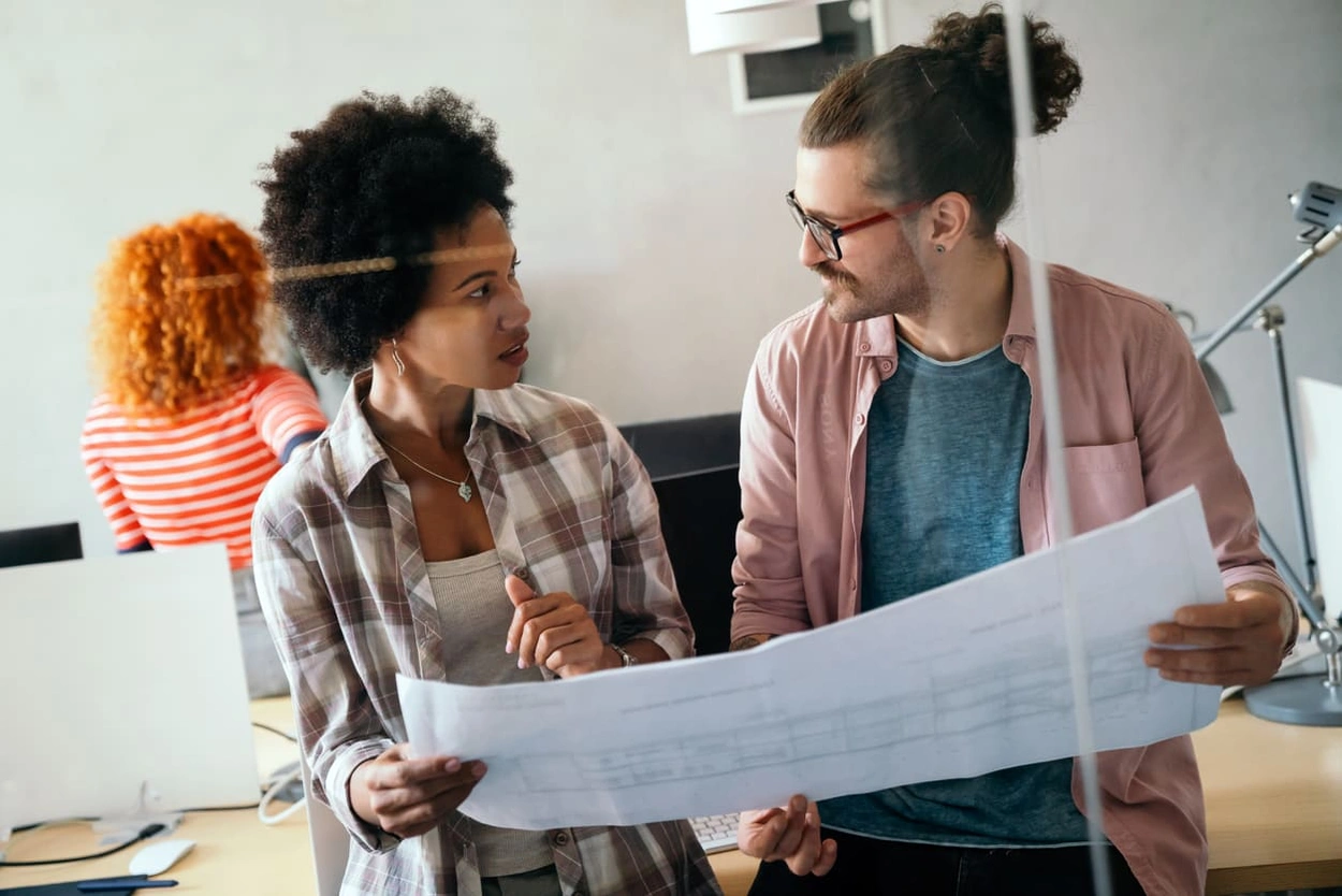 Coworkers discussing how to prevent large format printing mistakes