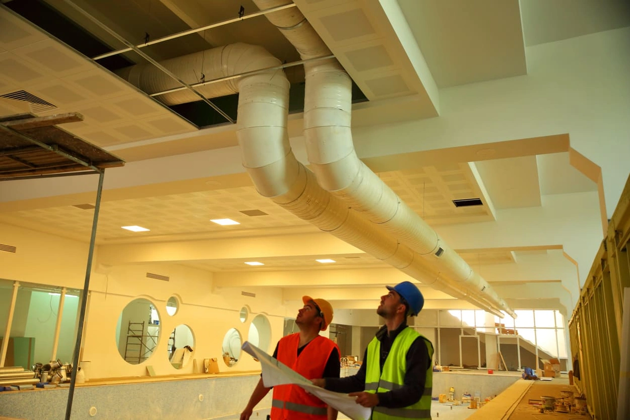 Construction workers using blueprints to ensure the correct placement of internal fixtures