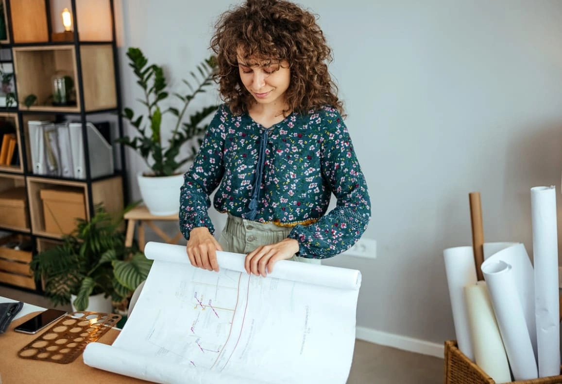 Architect making changes to a new plan printed on her office's printer and plotter