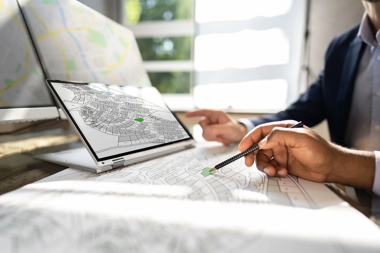 AEC professional comparing a printed map to a digital file for precise spatial data visualisation