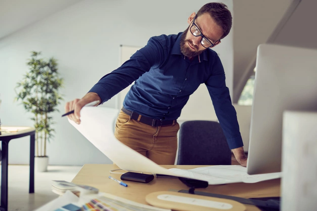 Architect looking at high-quality printouts after buying the right printer
