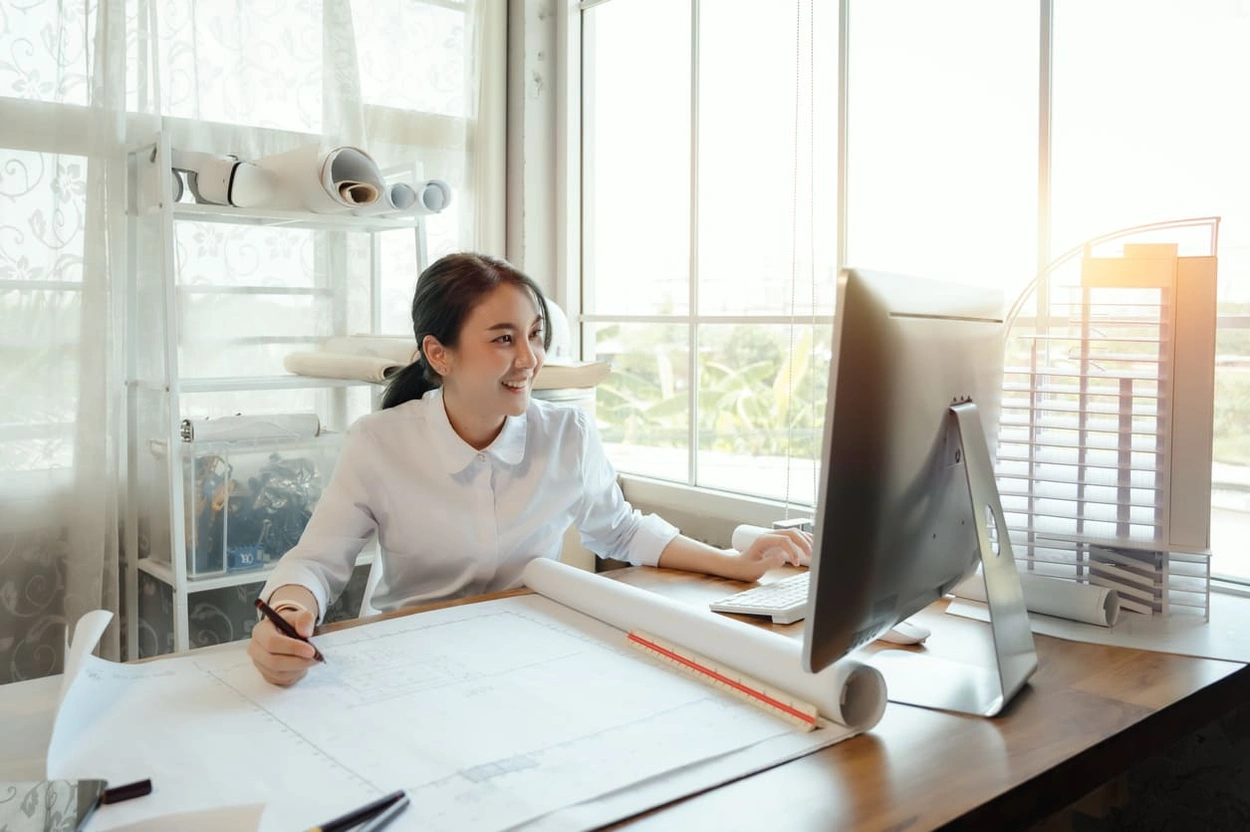Architect using BIM software on her computer to complete BIM cost estimating tasks Architect using BIM software on her computer to complete BIM cost estimating tasks