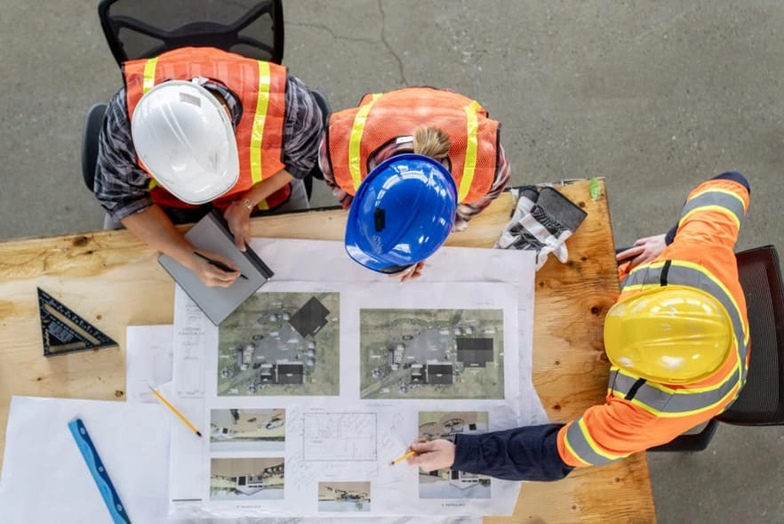 Construction team reviewing construction submittal prints Construction team reviewing construction submittal prints
